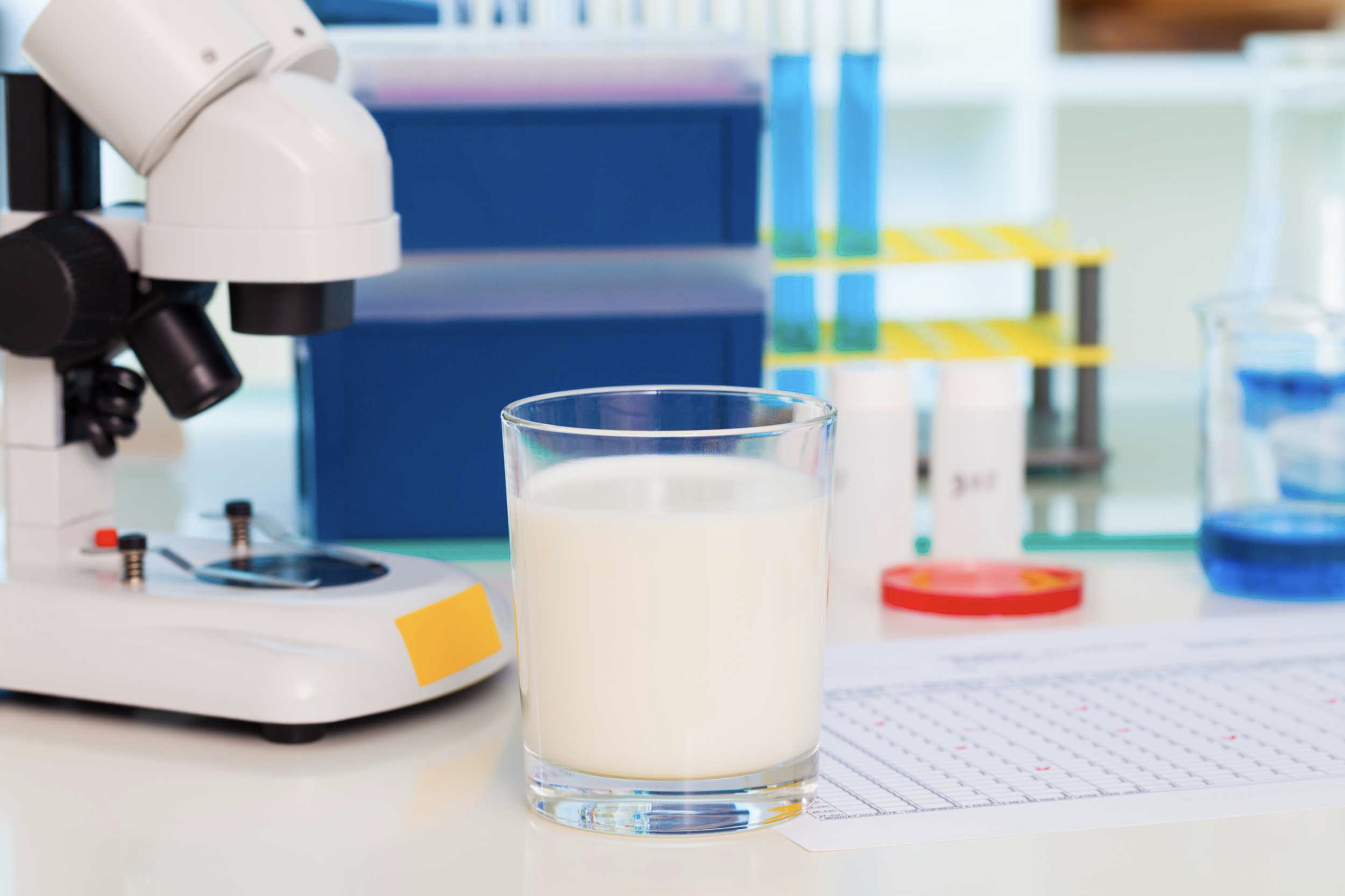 Un verre de lait devant un microscope
