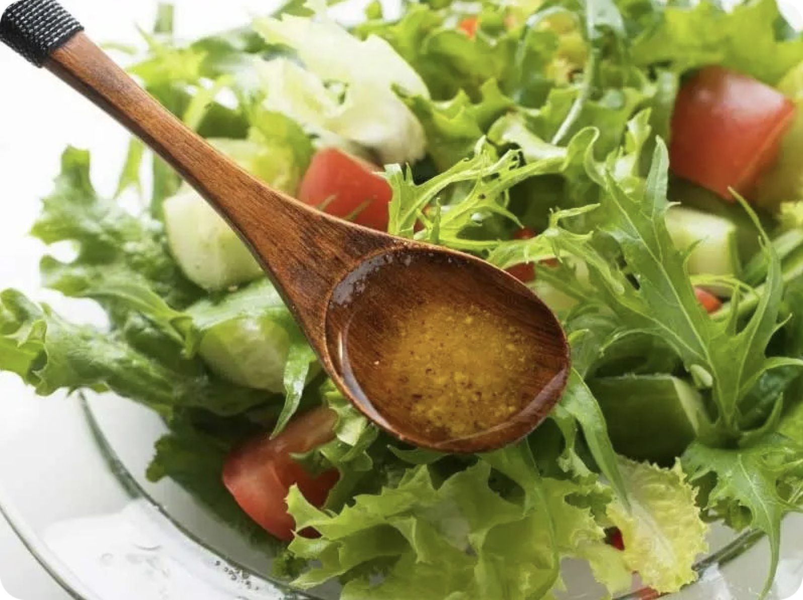 Une cuillère de vinaigrette au-dessus d'une salade